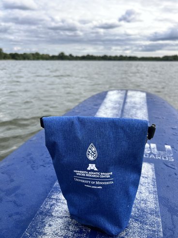 Blue dry bag on top of a stand up paddleboard in the middle of Lake Nokomis.